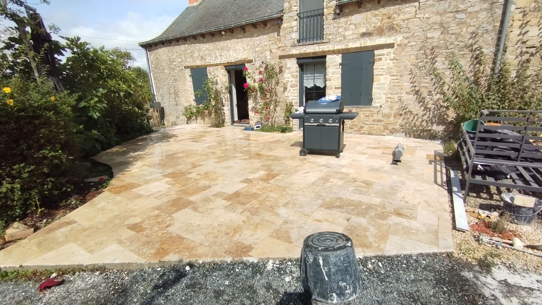 Terrasse en travertin devant maison en pierre par Permapaysage